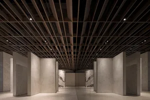 Interior of a modern office with marble walls and concrete columns.