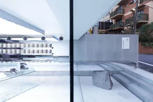 A modern retail space featuring glass and concrete materials with minimalist design elements.