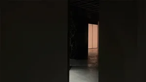 A minimalist, modern indoor passage with concrete walls and floor.
