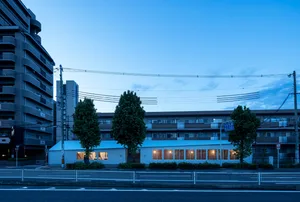 A modern commercial building with brick exterior and glass windows at dusk.