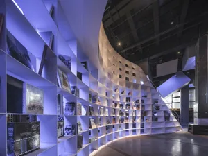 A modern bookshelf with metal shelves displaying various books and magazines in a contemporary setting.