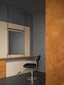 A stylish modern hair salon interior featuring a black leather chair, minimalistic design and wooden accents.