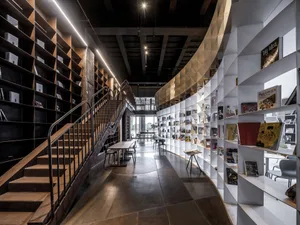 Interior view of a modern library with wooden shelves and tables.