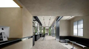 A sleek, modern corporate lobby with marble and concrete finishes, featuring mirrors and contemporary seating.