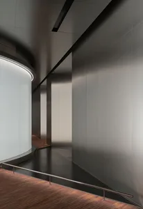 A modern interior design featuring a corridor with a metal-clad wall.