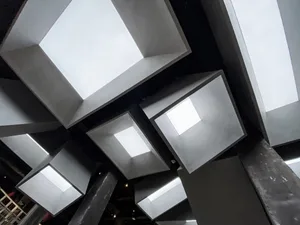 Modern installation art featuring metallic geometric shapes suspended from the ceiling.