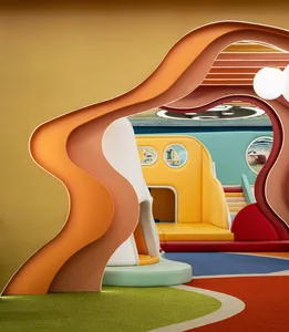 A vibrant and modern playroom with colorful soft foam structures and soft carpets.