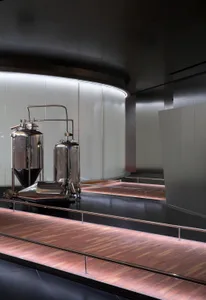 工業啤酒廠室內，展示金屬儲槽與弧形牆面。