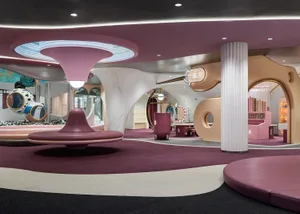 Modern retail store interior with curved pink soffit and soft furnishings
