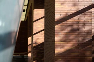 A close-up of modern brick walls with sunlight casting shadows, showcasing contemporary architectural design.