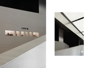 Modern interior space with concrete walls and floors, featuring minimalist furniture and light fixtures.