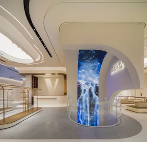 Modern retail space featuring concrete, glass walls, and illuminated lighting.