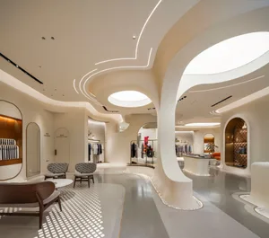 A modern retail space featuring a white interior with curved walls and a circular skylight.
