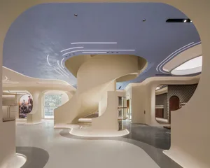 A modern retail space featuring white concrete elements and curved architectural details.