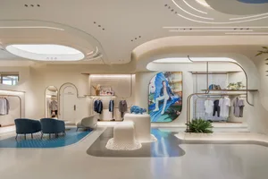 Modern retail store with minimalist design featuring glass walls, metal accents, and concrete flooring.