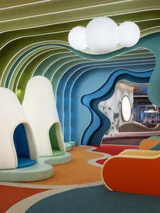 A playful and modern children's playroom with colorful soft furnishings and organic shapes.