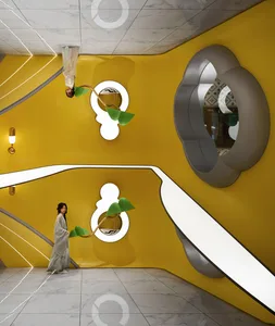 A modern interior design featuring vibrant yellow walls with sculptural wall art and a person standing in front of it.