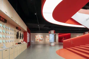 A minimalist exhibition space with a red acrylic ceiling and wooden accents.
