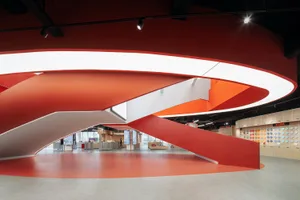 A modern commercial interior featuring concrete walls and red painted elements.