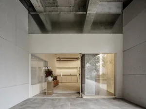 Modern storefront with concrete exterior and large glass panels.