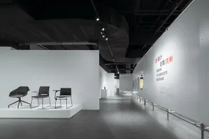 Modern exhibition space with minimalist design, featuring concrete and white materials.