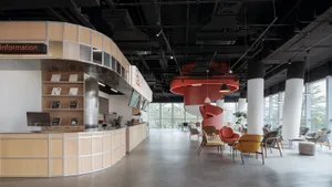 A modern office space featuring wooden desks and concrete flooring.