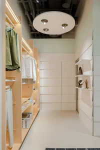 A neatly organized closet with shelves, racks, and lighting.