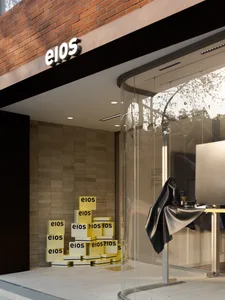 Stacked boxes with 'eios' printed on them inside a brick-clad storefront.