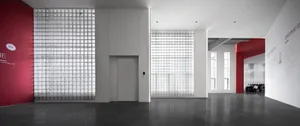 Minimalist office space featuring a glass block wall, with no visible furniture or decorations.