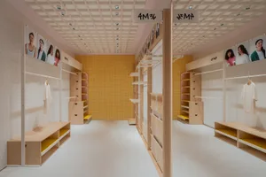A minimalist retail interior featuring wooden shelves and display units.