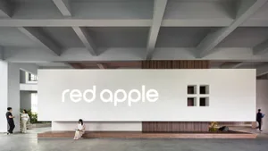 A modern and minimalist office space with white walls and a wooden table.