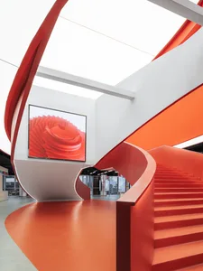 A modern interior design featuring a striking red staircase.