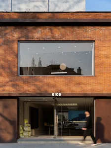 A modern retail storefront with large glass windows and a brick facade.