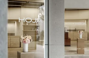 A modern retail storefront featuring glass and marble materials with wooden accents.