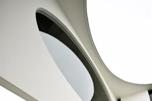 Modern architecture design featuring a sleek concrete ceiling with a large circular opening.