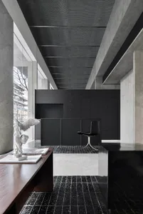 Modern office interior with a black and white concrete reception desk, minimalist design, concrete walls, and a sleek black c