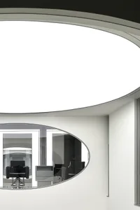 A view of a modern office space featuring large glass windows and a minimalist interior.
