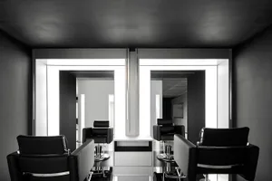 A modern salon interior featuring black cabinets and sleek, minimalist design.