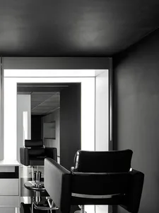 A minimalist salon with black leather chairs and metallic accents.