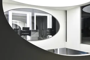 A modern office space featuring glass walls and contemporary office furniture.