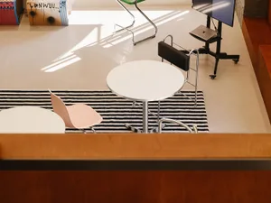 Industrial-style office space featuring a metal table, laminate flooring, and minimalist design.
