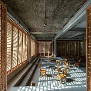 Industrial restaurant interior with concrete ceiling, wooden walls, and glazed windows.