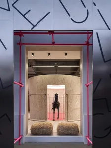 Industrial storefront with concrete elements and hay bales inside.