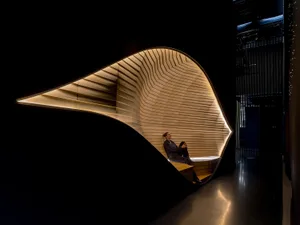 A modern interior design featuring a curved wooden wall with geometric patterns.
