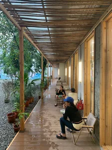 Cafe terrace with wooden ceiling, industrial design, and potted plants.
