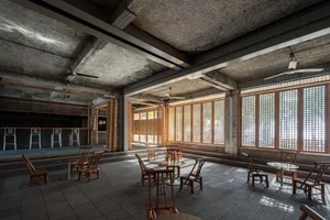 工業風餐酒吧，混凝土牆面、木質家具與大型窗戶。