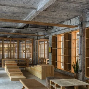 Industrial-style restaurant interior with wooden furniture and large open space.