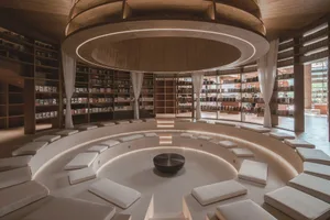 Circular, minimalist bookstore interior featuring wooden elements and seating.