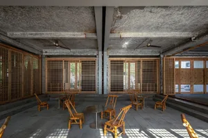 Minimalist coffee shop with wooden furniture and a concrete ceiling.