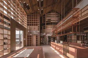現代圖書館室內，木質牆板搭配中央圓形書堆。